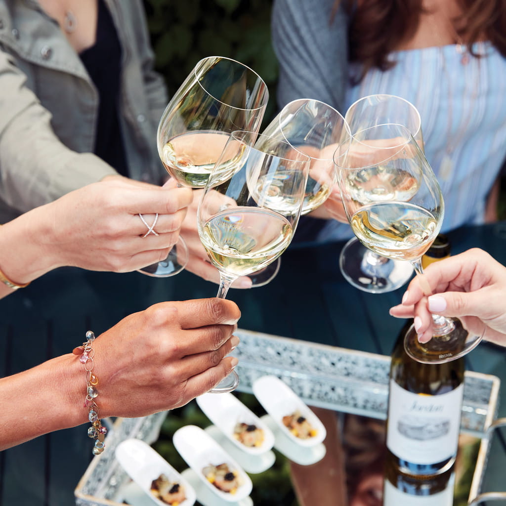 Cheersing with chardonnay before enjoying a wine pairing bite