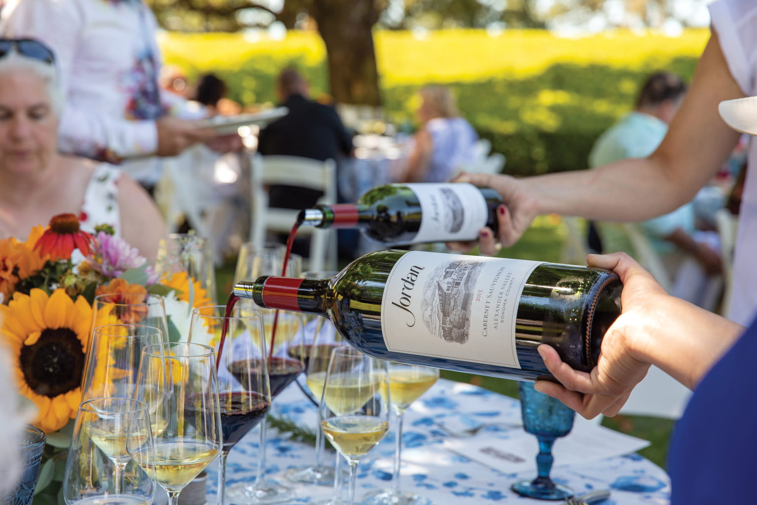 Pouring 2015 Jordan Cabernet Sauvignon for guests at a table