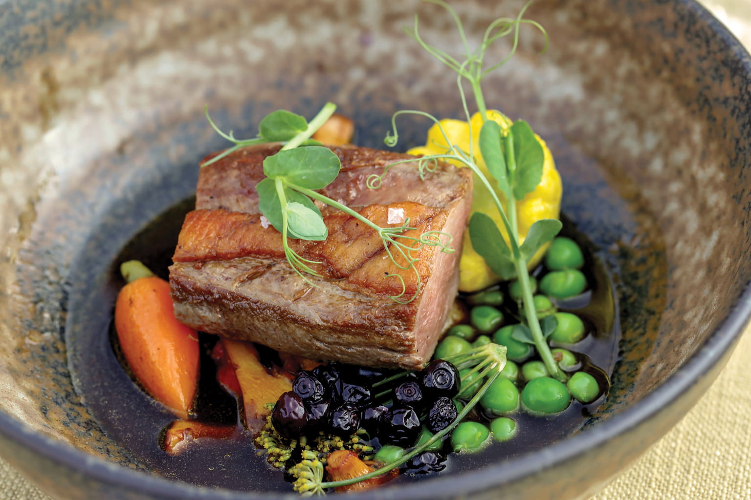 Pork dish with carrots, peas, huckleberries and pea tendrils
